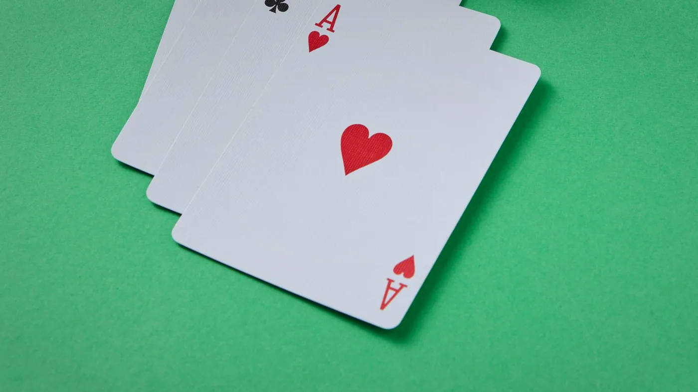 Three aces fanned out on the green felt
